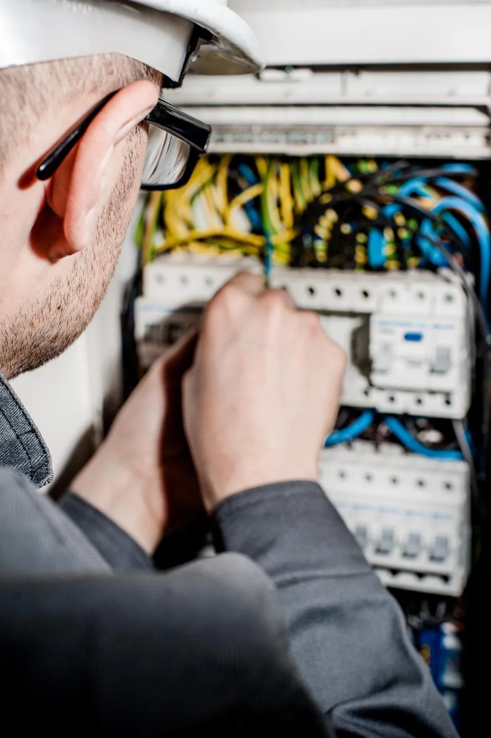Électricien intervenant sur un tableau ouvert lors d'une recherche de panne